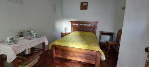 a small bedroom with a bed and a table at Cómoda habitación con baño privado in Sucre