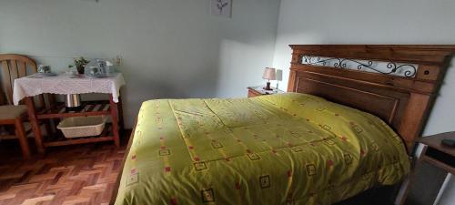 a bedroom with a bed with a yellow blanket on it at Cómoda habitación con baño privado in Sucre