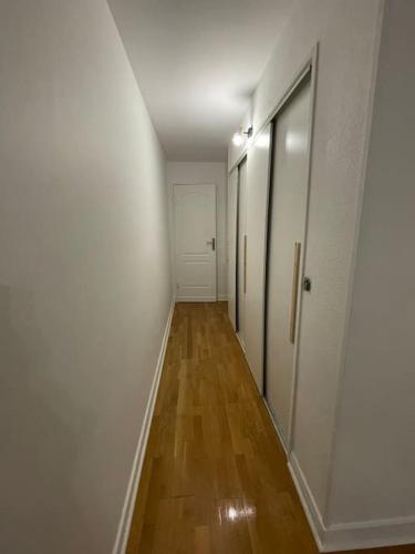 a hallway with white walls and a wooden floor at Super appartement à vitry-sur-seine in Vitry-sur-Seine
