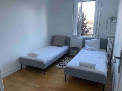 a small room with two beds and a window at Super appartement à vitry-sur-seine in Vitry-sur-Seine