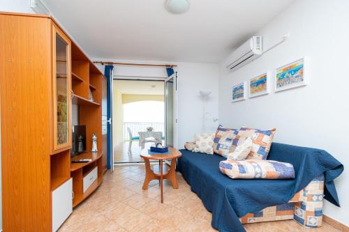 ein Wohnzimmer mit einem Sofa und einem Tisch in der Unterkunft Apartments by the sea Mandre, Pag - 4092 in Kolan