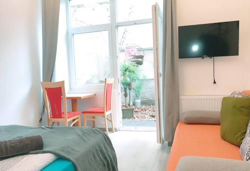 a room with a bed and a table and a tv at Comfort Triple room HN in Vienna