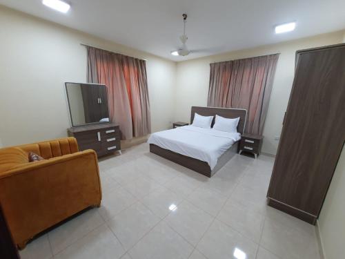 a bedroom with a bed and a tv and a couch at Terhal salalah 1 in Salalah