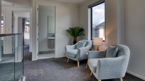 2 chaises et une table dans une chambre avec fenêtres dans l'établissement Experience The Magic of Riverside Living - 5 beds, à Hamilton