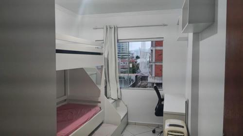 Habitación blanca pequeña con ventana y cama en Ed Hang, en Porto Belo