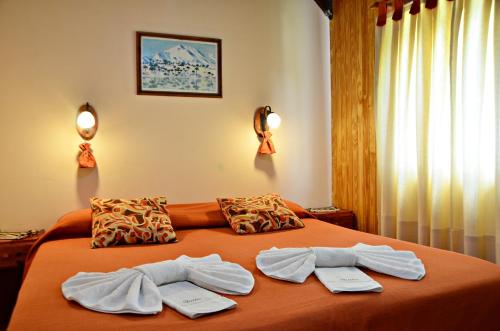 a bedroom with a bed with two towels on it at Hosteria Quiñe in Caviahue