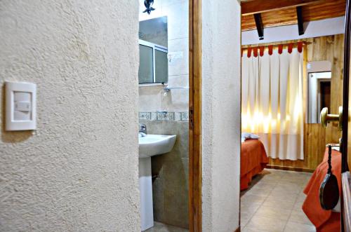 a bathroom with a sink and a bed in a room at Hosteria Quiñe in Caviahue