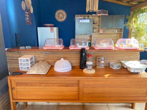 a wooden counter with bowls and other items on it at Noah Hostel & Chale in São Miguel do Gostoso