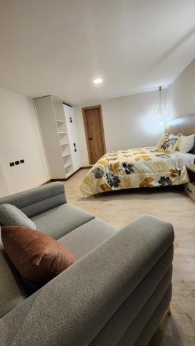 een woonkamer met een bank en een bed bij 203 La Terraza departamento in Cuenca