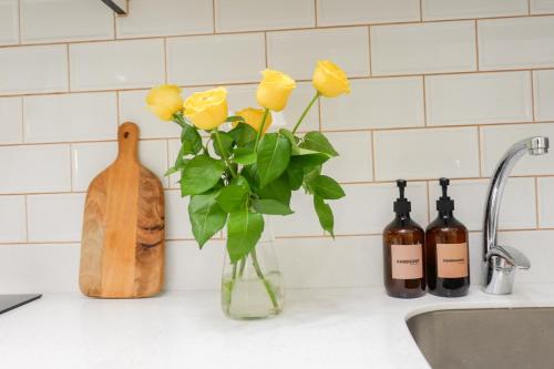 a vase with yellow roses on a kitchen counter at Queen Suite with City View at Acqua Private Residences in Manila