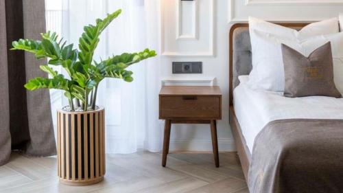 Un dormitorio con una cama y una mesa con una planta en Aparthotel ZATOR Retro 66 jacuzzi, en Zator