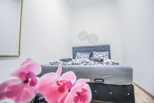 a bedroom with a bed with pink flowers in the foreground at Modern Double room HN in Vienna