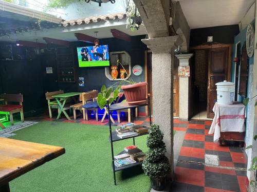 Habitación con mesa, sillas y TV. en Hotel Cristal, en Antigua Guatemala