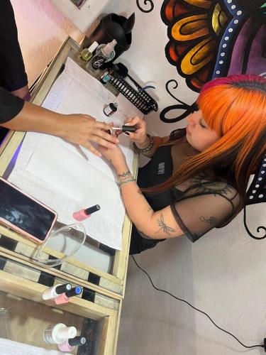 a woman with orange hair is sitting at a table at Cristales de Antigua Hotel Cristal in Antigua Guatemala