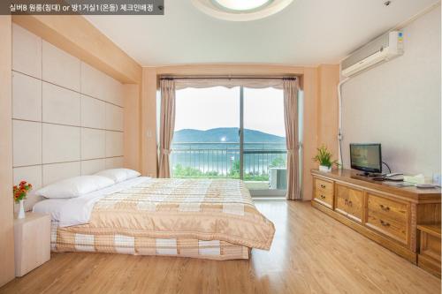 a bedroom with a bed and a large window at Gyeongju Ilsung Condo in Gyeongju