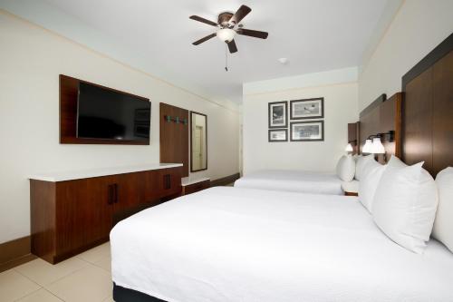 a bedroom with two beds and a flat screen tv at Sand Rose Beach Resort in South Padre Island