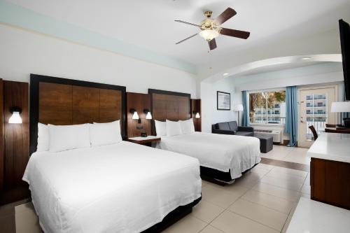 a hotel room with two beds and a ceiling fan at Sand Rose Beach Resort in South Padre Island