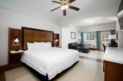 a bedroom with a large bed and a living room at Sand Rose Beach Resort in South Padre Island
