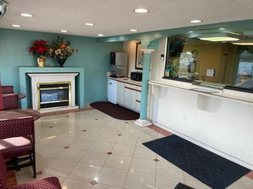 a living room with a fireplace and a kitchen at Express Inn-Rahway in Rahway