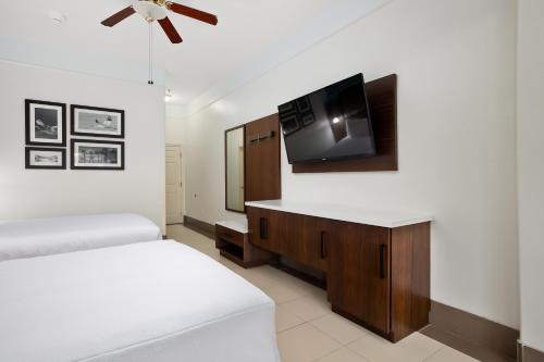 a bedroom with two beds and a flat screen tv at Sand Rose Beach Resort in South Padre Island