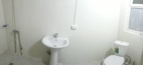 a white bathroom with a sink and a toilet at Космос in Bishkek