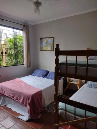 a bedroom with two bunk beds and a window at Pousada Cantinho D´Lilica in Balneário Praia do Leste