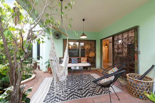 a porch with two chairs and a swing at Where Enchanted Garden meets Tropical Paradise in Darwin