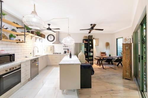une cuisine avec des appareils électroménagers blancs et une salle à manger dans l'établissement The Enchanted Garden - Breezy Tropical Allure, à Darwin