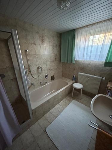 ein Badezimmer mit einer Badewanne und einem Waschbecken in der Unterkunft Ferienwohnunghaus Kellermann in Moosbach