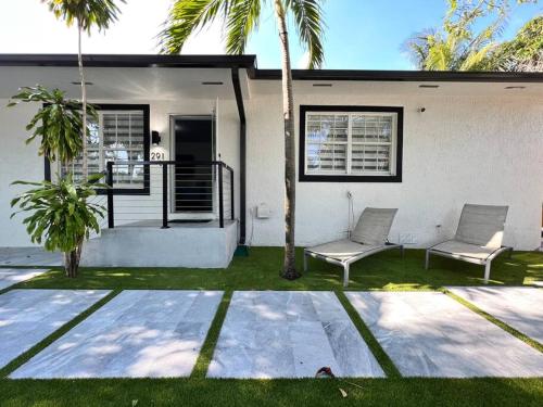 two chairs in front of a house with palm trees at Stylish 3/2 centrally located! in Miami