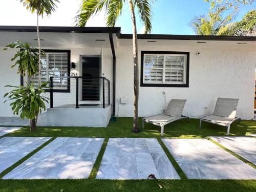 two chairs in front of a house with palm trees at Stylish 3/2 centrally located! in Miami
