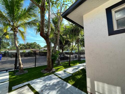 a house with palm trees next to a fence at Stylish 3/2 centrally located! in Miami