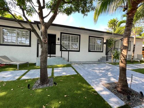 two palm trees in front of a house at Stylish 3/2 centrally located! in Miami