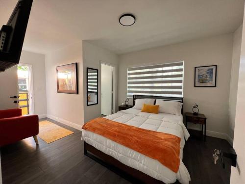 1 dormitorio con 1 cama grande con manta naranja en Stylish 3/2 centrally located!, en Miami