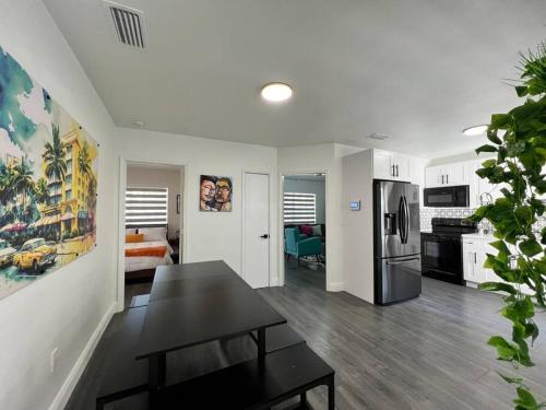 cocina y sala de estar con mesa y nevera en Stylish 3/2 centrally located!, en Miami