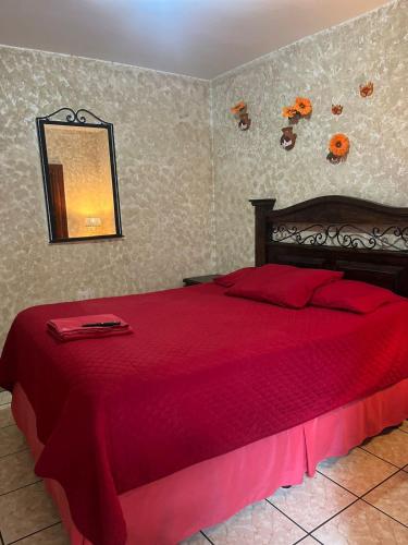 a bedroom with a red bed with a red blanket at Cristales de Antigua Hotel Cristal in Antigua Guatemala