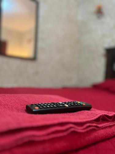 a remote control sitting on top of a red blanket at Cristales de Antigua Hotel Cristal in Antigua Guatemala