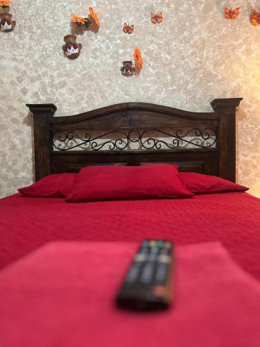 a remote control sitting on top of a red bed at Cristales de Antigua Hotel Cristal in Antigua Guatemala