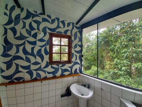 uma casa de banho com um lavatório e uma janela em Casinha acolhedora da mata - Rota do Vinho em São Roque