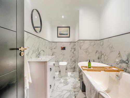 a white bathroom with a tub and a sink at East View House in Middleton in Teesdale