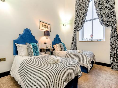 two beds in a room with blue and white at East View House in Middleton in Teesdale