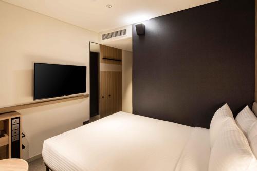 a bedroom with a white bed and a black wall at Sotetsu Fresa Inn Seoul Myeong-dong in Seoul