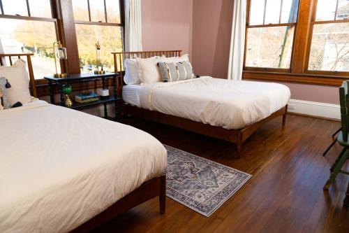 a bedroom with two beds and two windows at 4 Bedroom Suite At The Historic Winona House in Roanoke