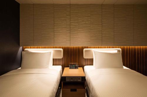 two beds sitting next to each other in a room at Sotetsu Fresa Inn Seoul Myeong-dong in Seoul