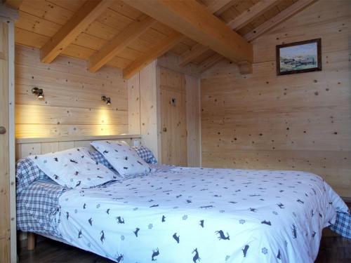 une chambre avec un lit dans une cabane en bois dans l'établissement Chalet familial, 5 chambres, hammam, cheminée, près des pistes - FR-1-467-44, au Grand-Bornand