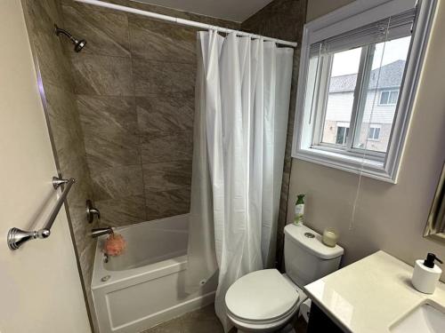 a bathroom with a toilet and a shower and a window at No available not in Welland