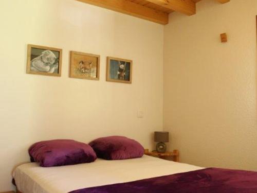 une chambre avec un lit avec deux oreillers dessus dans l'établissement Superbe appartement 5 pers avec balcon au Grand-Bornand - FR-1-467-86, au Grand-Bornand