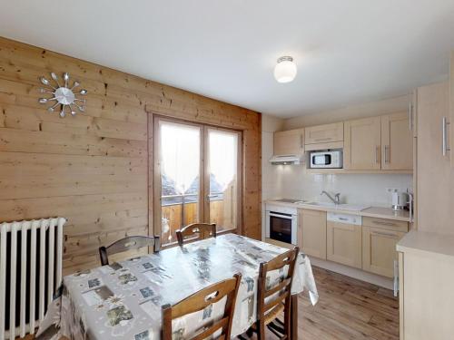 une cuisine avec une table et des chaises dans une pièce dans l'établissement Appartement confortable 4 pers, proche commerces et pistes, parking inclus - FR-1-467-54, au Grand-Bornand