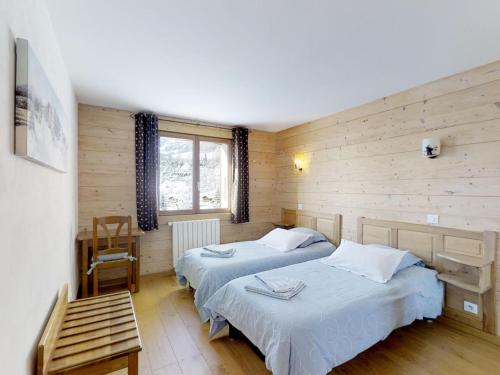 a bedroom with two beds and a table and a chair at Appartement Le Grand-Bornand, 5 pièces, 9 personnes - FR-1-467-57 in Le Grand-Bornand