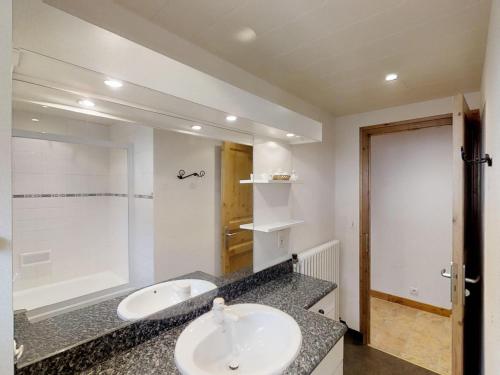 une salle de bain avec un lavabo et un grand miroir dans l'établissement Appartement cosy avec balcon, proche des pistes et village - 6 pers, parking inclus - FR-1-467-48, au Grand-Bornand